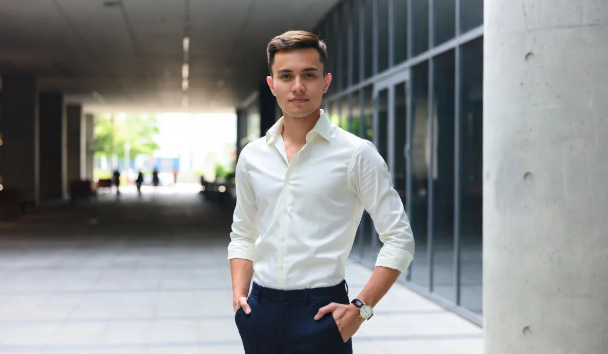Молодой человек в белой рубашке и темных брюках
